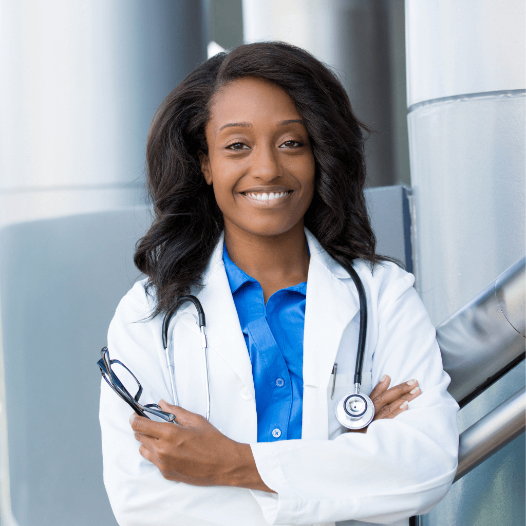 black female doctor, arms crossed, stethoscope around neck, smiling