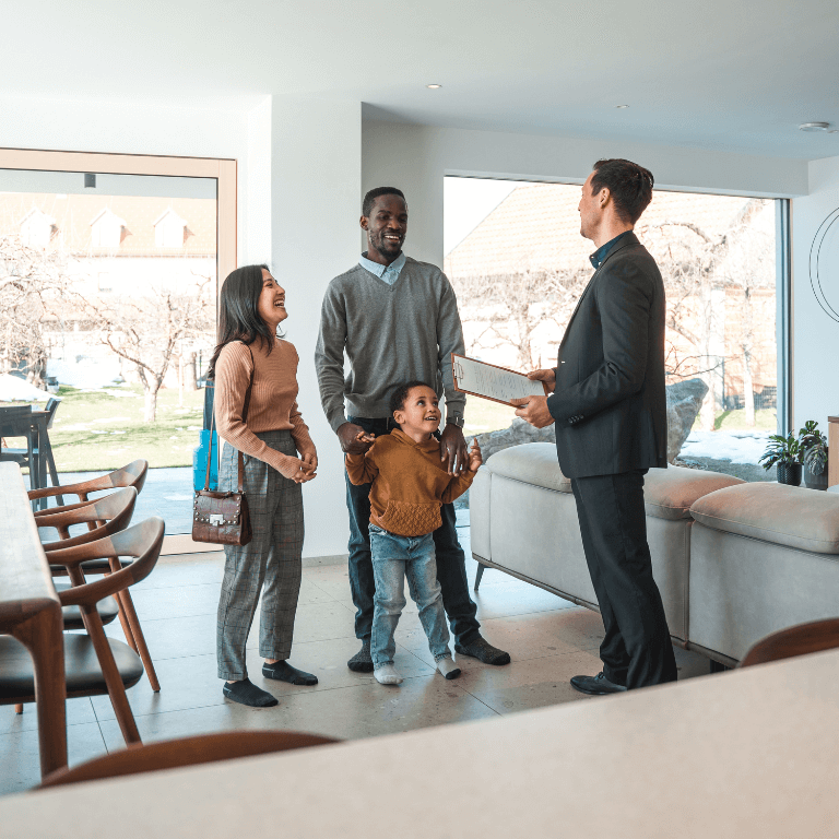 multi-racial family touring a home with their real estate agent.