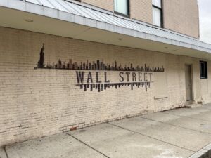 Wall Street painted on a yellow brick building